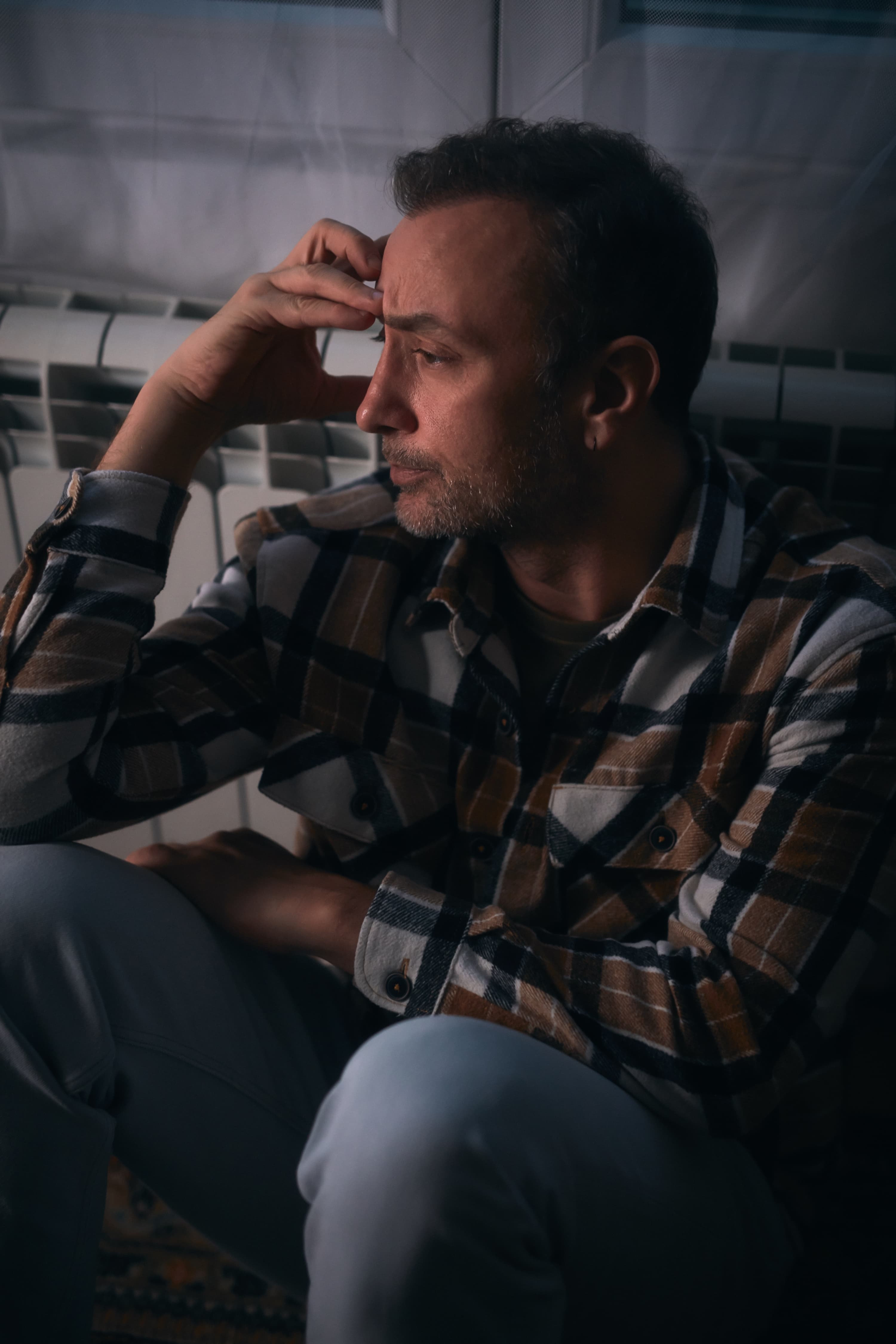 người đàn ông lo lắng ngồi trên sàn nhà